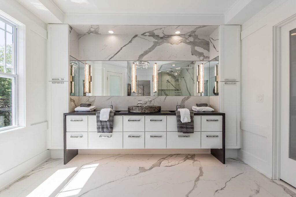 custom frameless mirror over a white vanity as part of mirror installation services from Swan Manufacturing